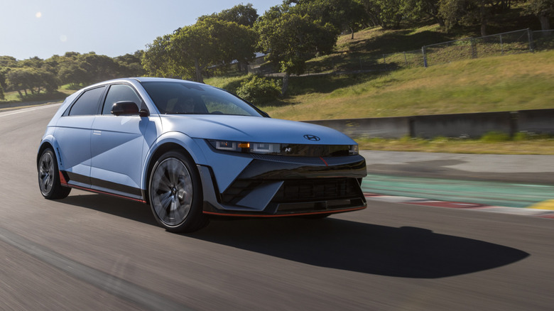 Front 3/4 view of blue Hyundai Ioniq 5 N driving on race track.
