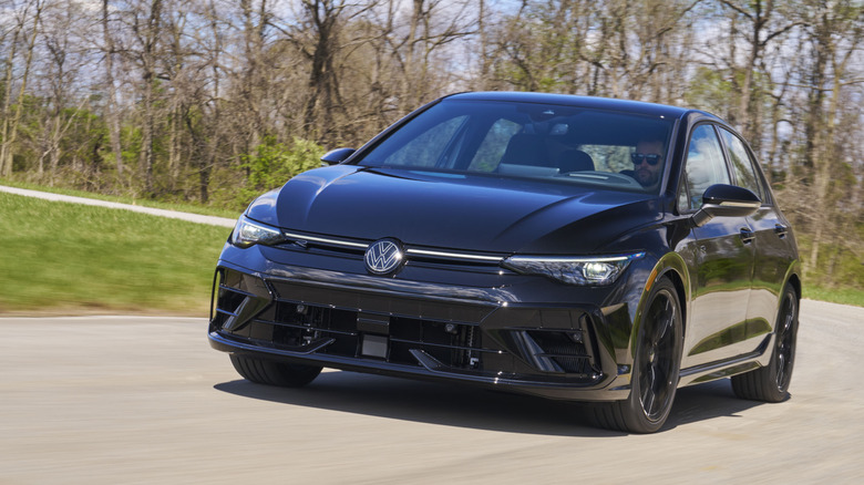 Front view of black Volkswagen Golf R on rural road.