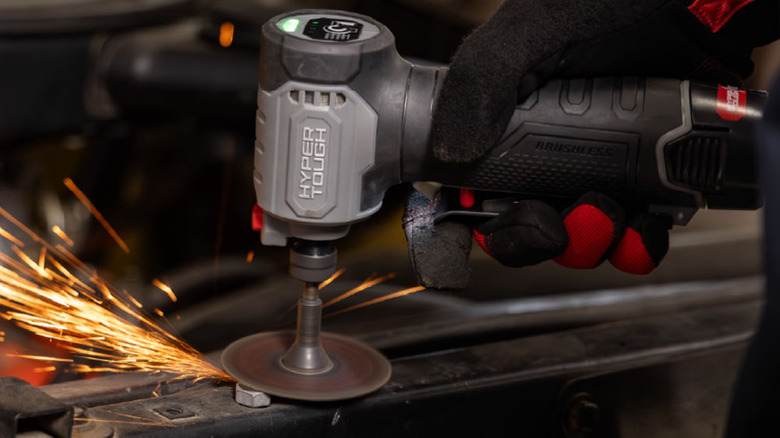 A person using die grinder on bolt