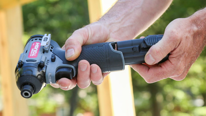 A person holding a cordless impact driver