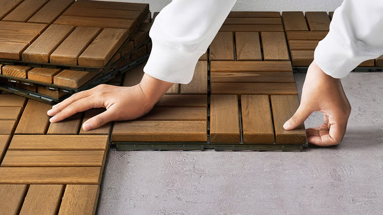 A person putting wood themed decking down