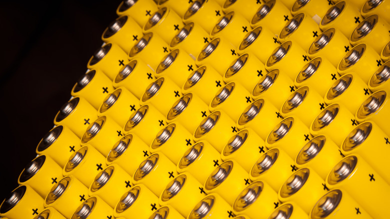 Yellow AA batteries lined up on a black background.