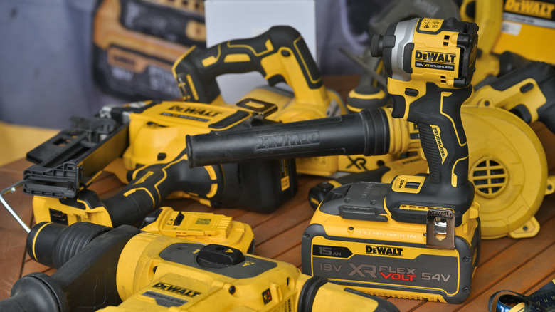 A a pile of DeWalt tools on a wooden table.