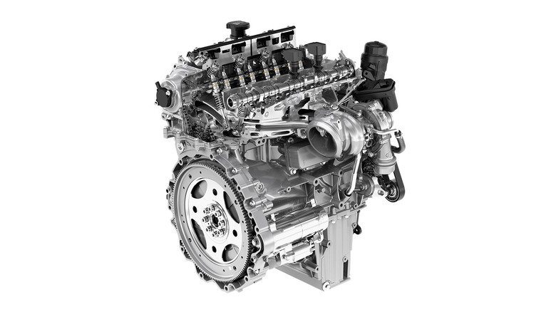 A silver and gray Land Rover Ingenium engine against a white studio background, right three-quarter view shown