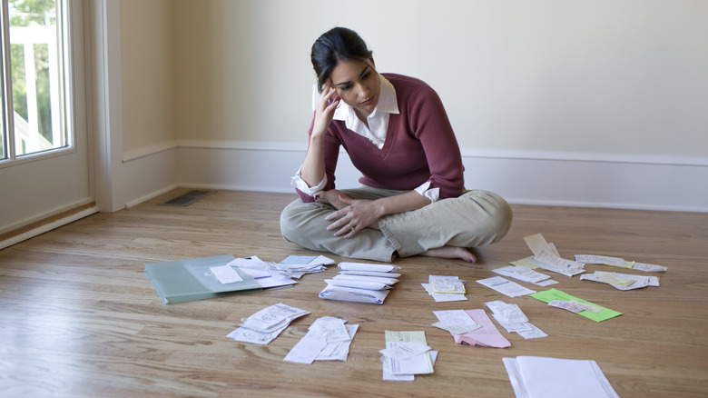 person looking at bills on the floor