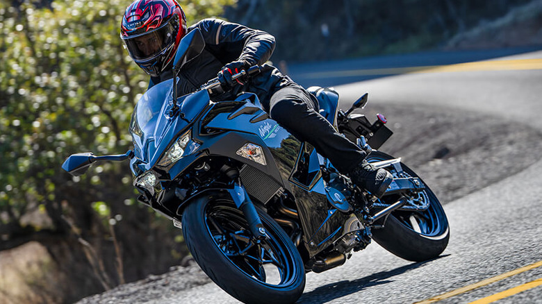 front profile view of the 2024 Kawasaki Ninja 500 riding down a curved road