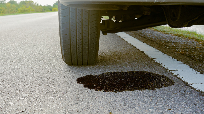 Oil leaking from a car that is parked by the road