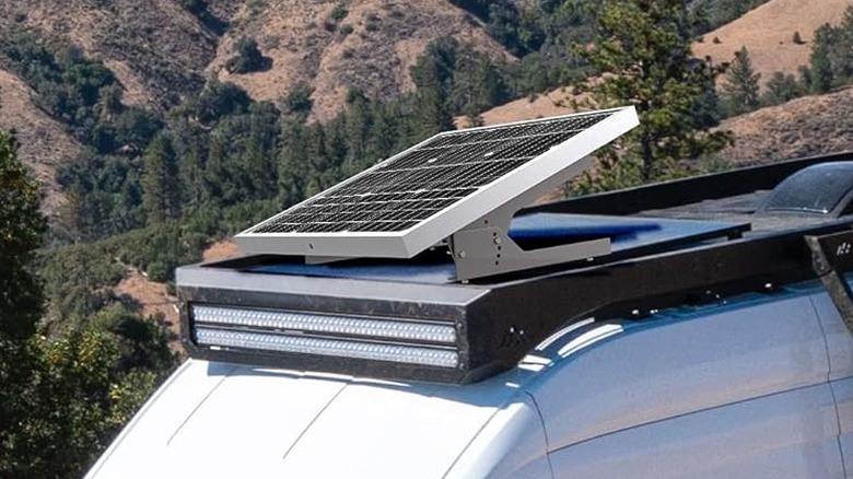 A solar panel on the roof of a van angled to get energy.