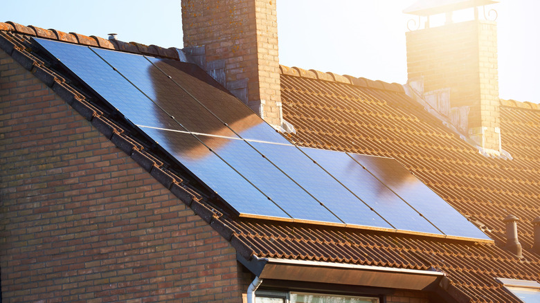 Close-up of rooftop solar panels and chimney.