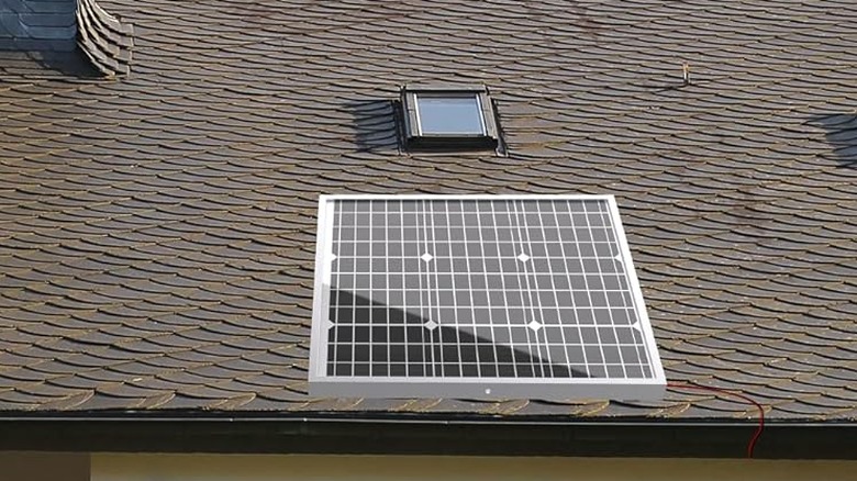 A solar panel on a roof gathering energy from the sun.