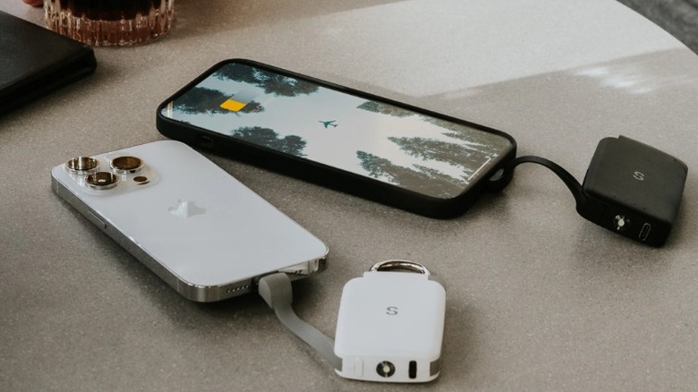 Black and white SnapWireless PowerPack Nano power banks charging phones on a table