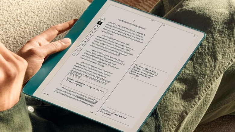 Hand holding an Amazon Kindle Scribe tablet displaying a document