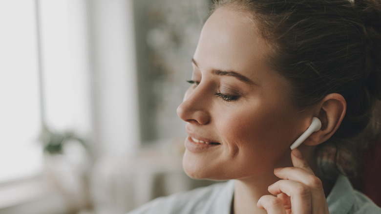 Woman wearing white earbud headphones