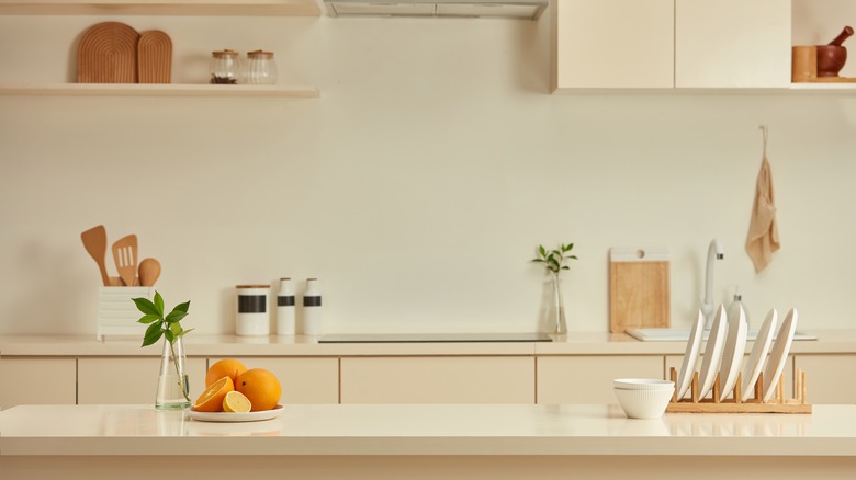 A simple, beige kitchen view with various utensils