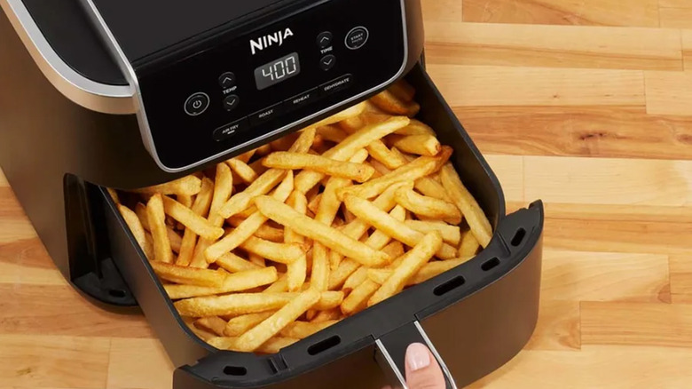 A Ninja branded air fryer with French fries in it