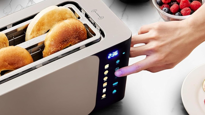A person adjusting the settings of a smart toaster oven
