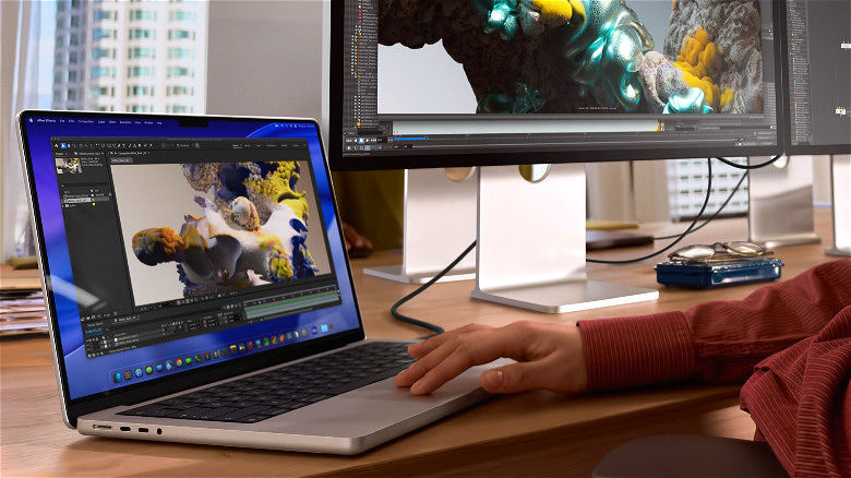 The MacBook Pro M5 in use on a desk next to a desktop PC.