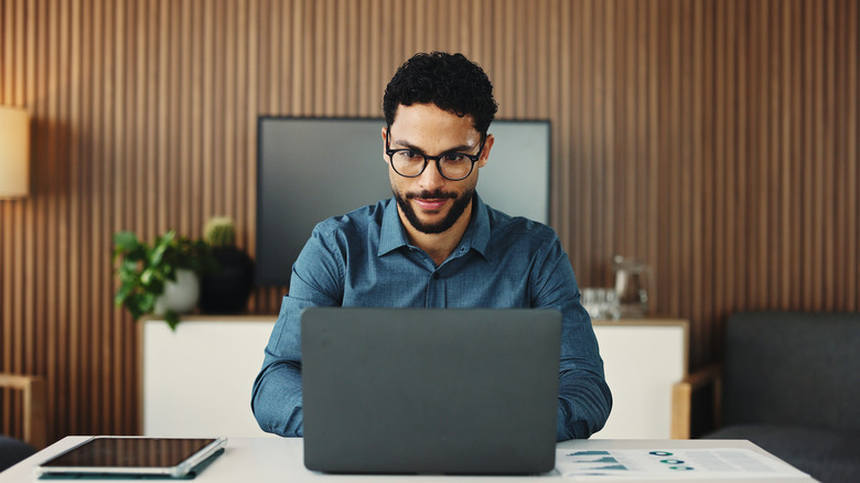 A man typing on a laptop on a desk