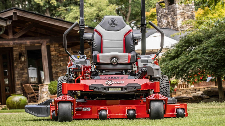 An Exmark Lazer Z zero turn riding mower on a large lawn.