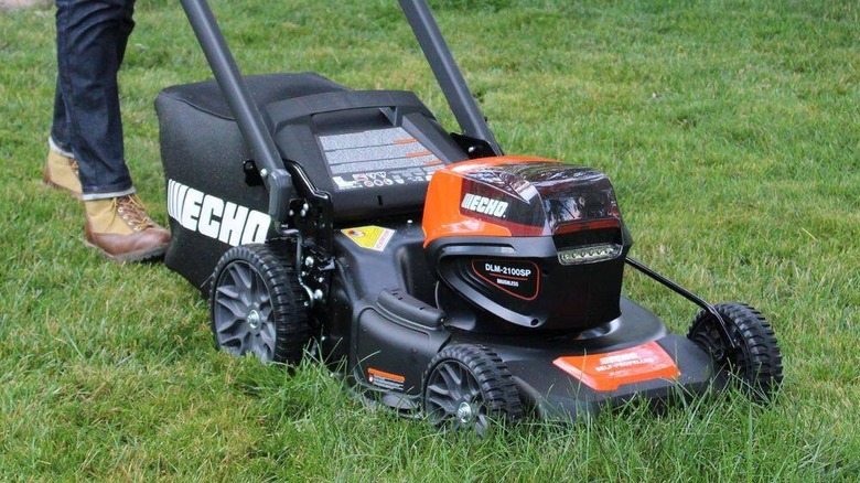 Close-up of the Echo 56V mower with a person pushing it in the background