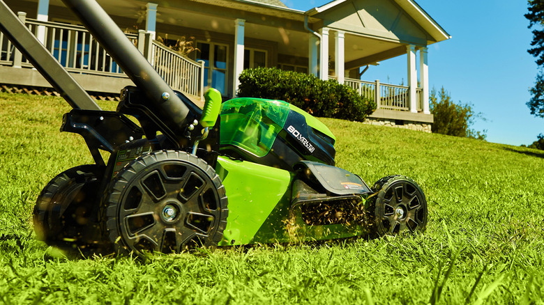 Greenworks 80V mower sending grass trimmings flying, side view