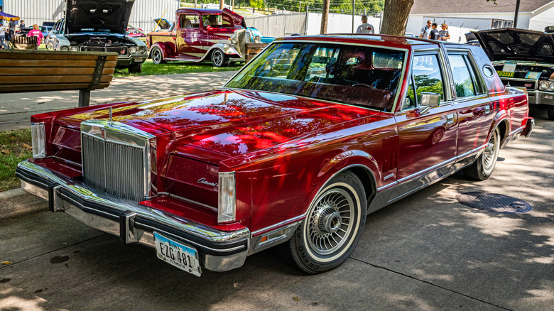 Front 3/4 view of red Lincoln Continental Mark VI at car show.