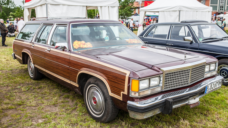 Front 3/4 view of brown Ford Country Squire station wagon parked at car show.