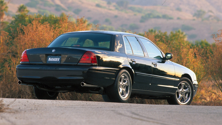 Rear 3/4 view of black 2003 Mercury Marauder parked in countryside.