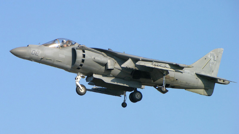 An AV-8B Harrier II hovering in midair on a clear day