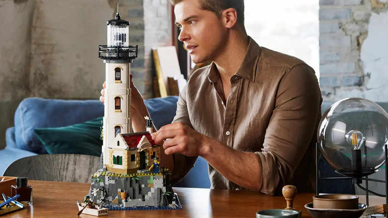 A man building the LEGO Ideas: Motorized Lighthouse.