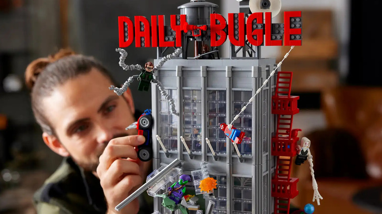 A man playing with the Marvel: Daily Bugle set.