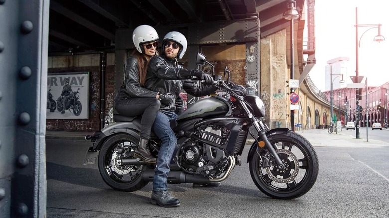 Two riders stopped on a Kawasaki Vulcan S, side view