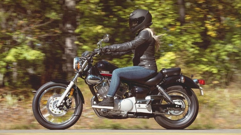 Person riding Yamaha V Star 250 down woodland highway