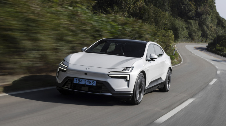 A white Polestar 4 on the road, front 3/4 view, Korean license plates