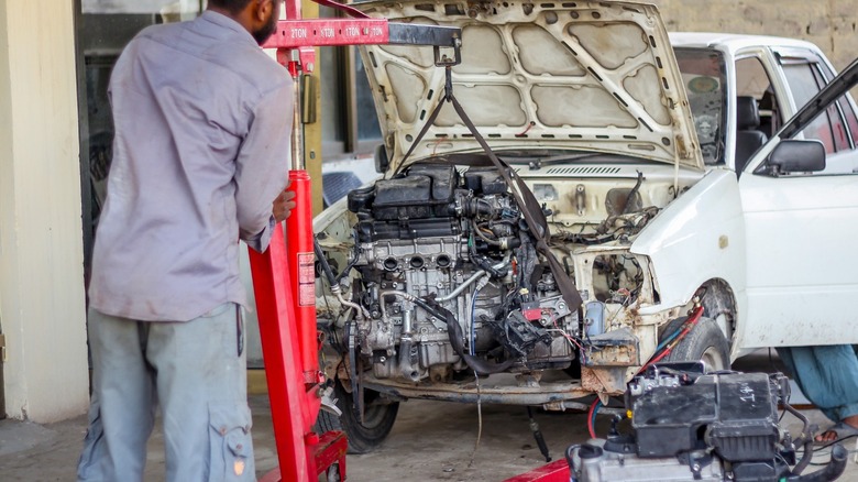 mechanic removing car engine