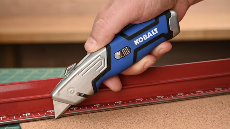 person using Kobalt utility knife on cork