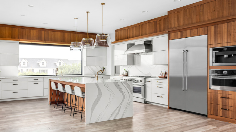 A designer kitchen with high-end appliances and marble countertops in neutral colors