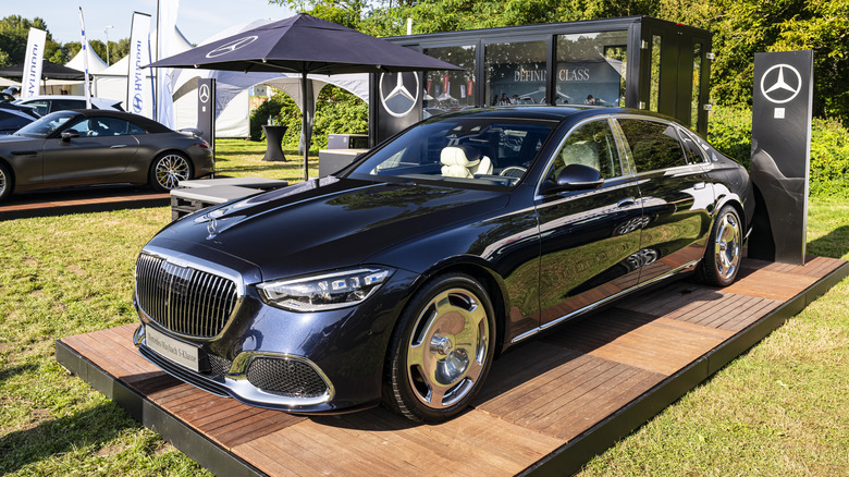A Maybach Mercedes S-Class parked on a lawn for display, front 3/4 view