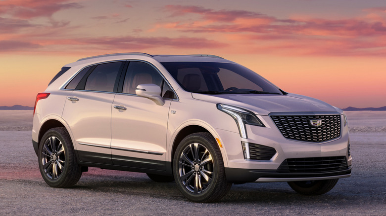 Front 3/4 view of 2026 Cadillac XT5 on dirt road at sunset