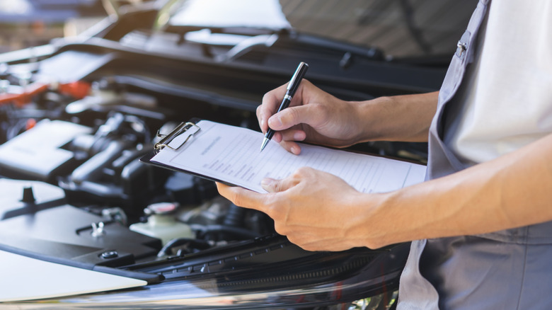 Mechanic with clipboard in auto shop