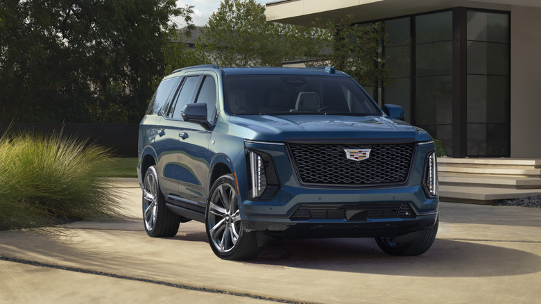 2025 Cadillac Escalade in front of modern home, front-right 3/4 view