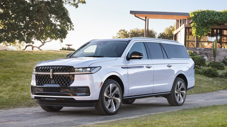 2025 Lincoln Navigator L with modern home in background, front-left 3/4 view