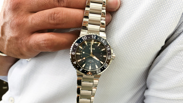 Person holding an Oris watch.