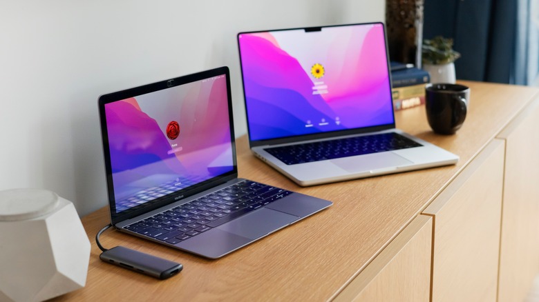 two MacBooks open on a desk