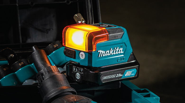 Makita CXT flashlight illuminating a dark tool box.