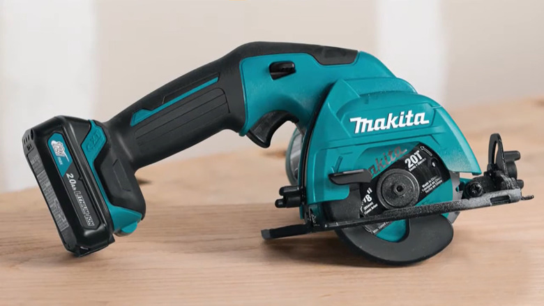 Makita CXT12V circular saw sitting on a wooden surface.