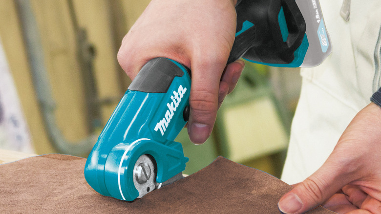 Makita CXT 12V multi-cutting tool being used to cut through thin material.