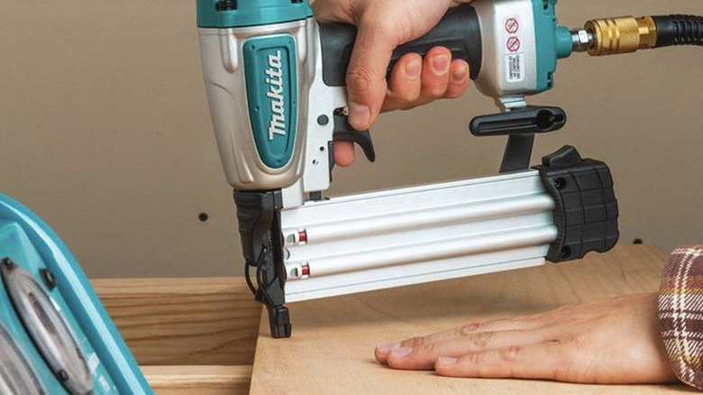 person using Makita nailer