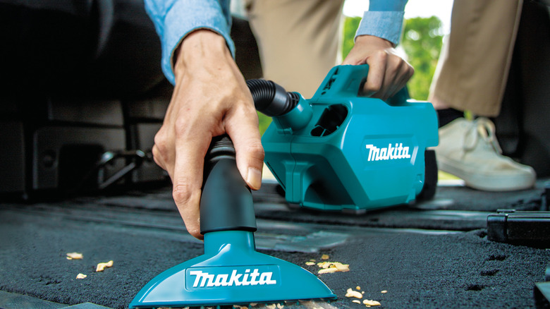 Cleaning up car floor with the LXT vacuum cleaner by Makita.