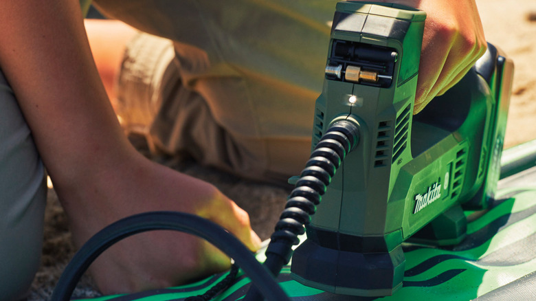 Blowing up an inflatable toy on a beach with Makita's LXT inflator.